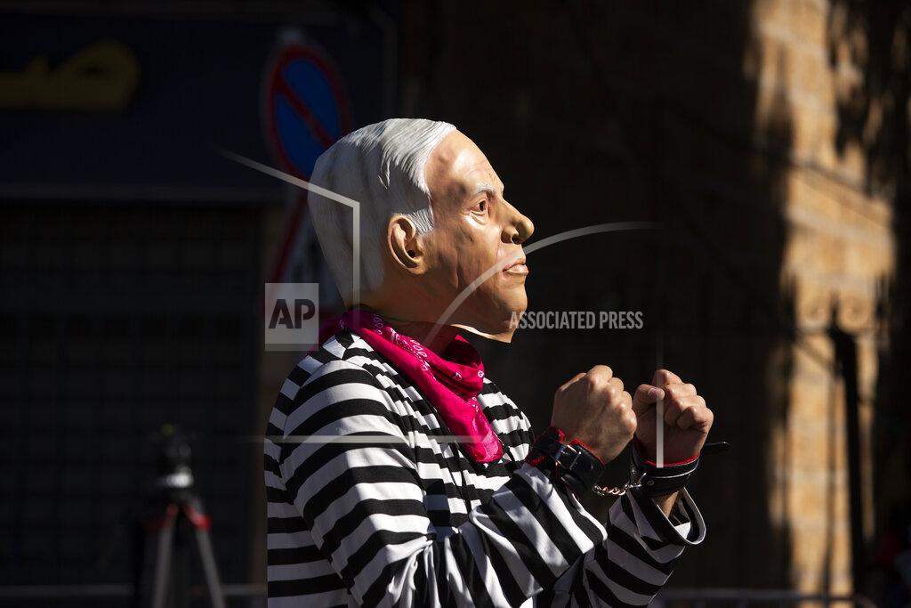 Maya Alleruzzo A protester wearing a mask depicting Israeli Prime Minister Benjamin Netanyahu poses for photographers outside the District Court during Netanyahu's corruption trial in Jerusalem, Monday, Feb. 8, 2021. Netanyahu has pleaded not guilty as his trial on corruption charges resumes in a Jerusalem courtroom just weeks before national elections in which he hopes to extend his 12-year rule. (AP Photo/Maya Alleruzzo)