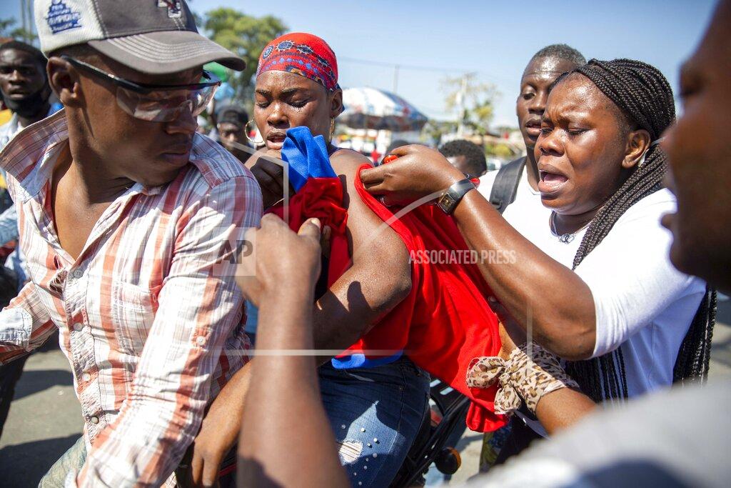 Dieu Nalio Chery An injured protester is helped by others during a protest to demand the resignation of Haiti's president Jovenel Moise in Port-au-Prince, Haiti, Wednesday, Jan. 20, 2021. Moise has one more year in power, but a growing groundswell of opposition is organizing protests and demanding he resign next month amid spiraling crime and a crumbling economy. ( AP Photo/ Dieu Nalio Chery)