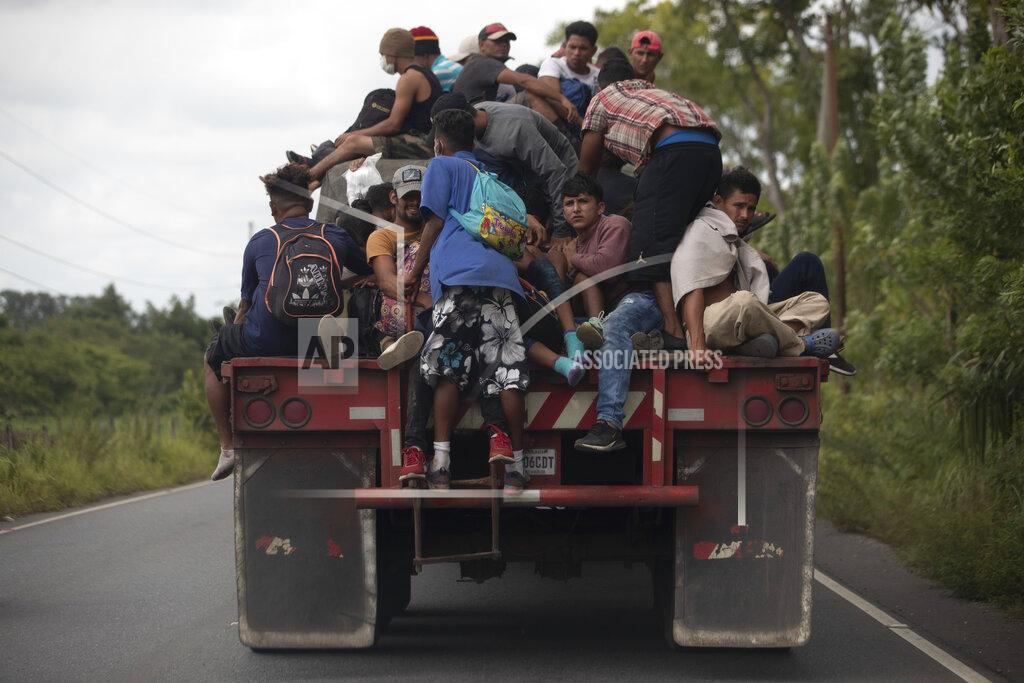 Moises Castillo FILE - In this Oct. 2, 2020 file photo, migrants ride on the back of a freight truck that slowed down to give them an opportunity to jump on in Rio Dulce, Guatemala. Mauro Verzzeletti, director of the Casa del Migrante in Guatemala City, said the storms Eta and Iota will increase poverty on top of the violence people already faced, forcing more to migrate. (AP Photo/Moises Castillo, File)