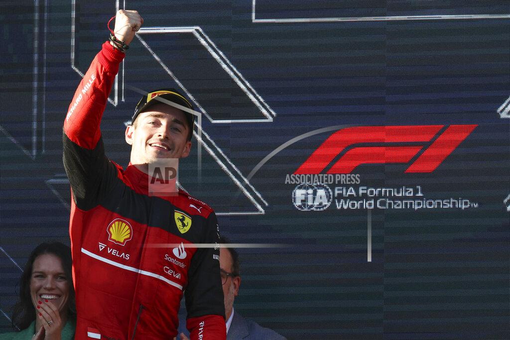 Asanka Brendon Ratnayake Ferrari driver Charles Leclerc of Monaco gestures as he gets onto the podium after winning the Australian Formula One Grand Prix in Melbourne, Australia, Sunday, April 10, 2022.Red Bull driver Sergio Perez, left, of Mexico was second. (AP Photo/Asanka Brendon Ratnayake)