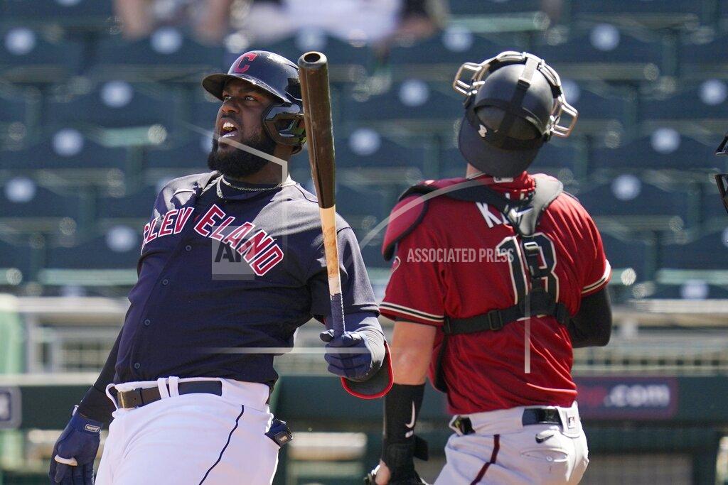 Ross D. Franklin Cleveland Indians designated hitter Franmil Reyes, left, shouts after fouling off a pitch as Arizona Diamondbacks catcher Carson Kelly, right, looks for the ball during the second inning of a spring training baseball game Wednesday, March 3, 2021, in Goodyear, Ariz. (AP Photo/Ross D. Franklin)