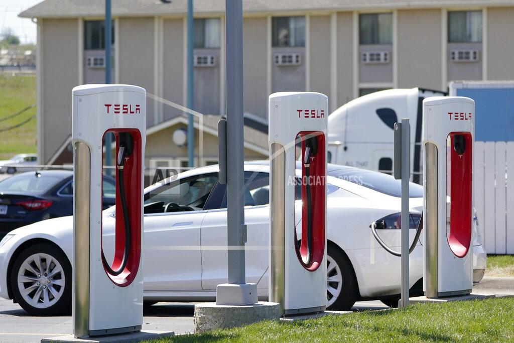 Orlin Wagner A Tesla charges at a station in Topeka, Kan., Monday, April 5, 2021. The president and the auto industry maintain the nation is on the cusp of a gigantic shift to electric vehicles and away from liquid-fueled cars, but biofuels producers and some of their supporters in Congress aren’t buying it. They argue the U.S. should increase sales of ethanol and biodiesel, not abandon them. (AP Photo/Orlin Wagner)
