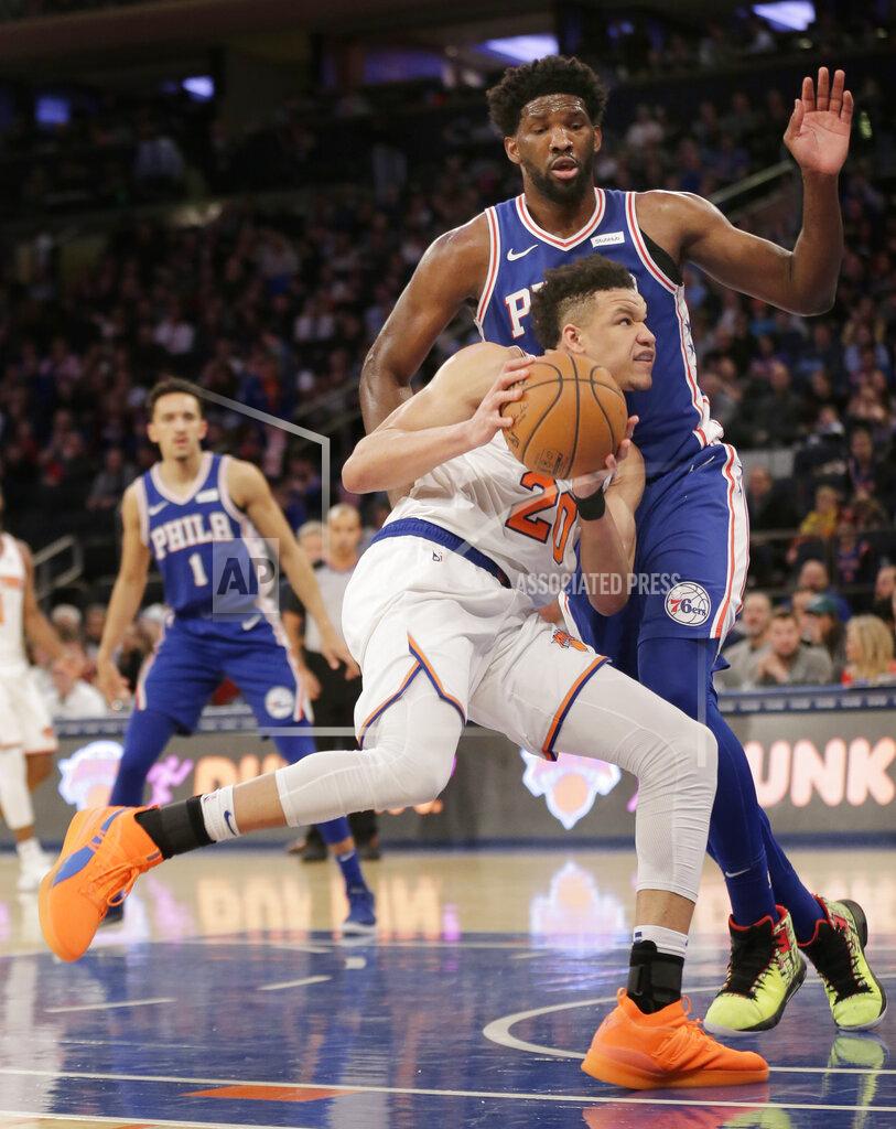 Seth Wenig New York Knicks' Kevin Knox, bottom, tries to push past Philadelphia 76ers' Joel Embiid during the second half of the NBA basketball game, Sunday, Jan. 13, 2019, in New York. (AP Photo/Seth Wenig)