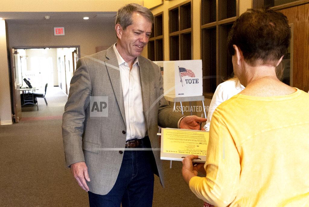 Eileen T. Meslar Jim Pillen turns his ballot into Linda Paitz at his polling place, Columbus Berean Church, in Columbus, Nebraska, on Tuesday, May 10, 2022. (Eileen T. Meslar/Omaha World-Herald via AP)