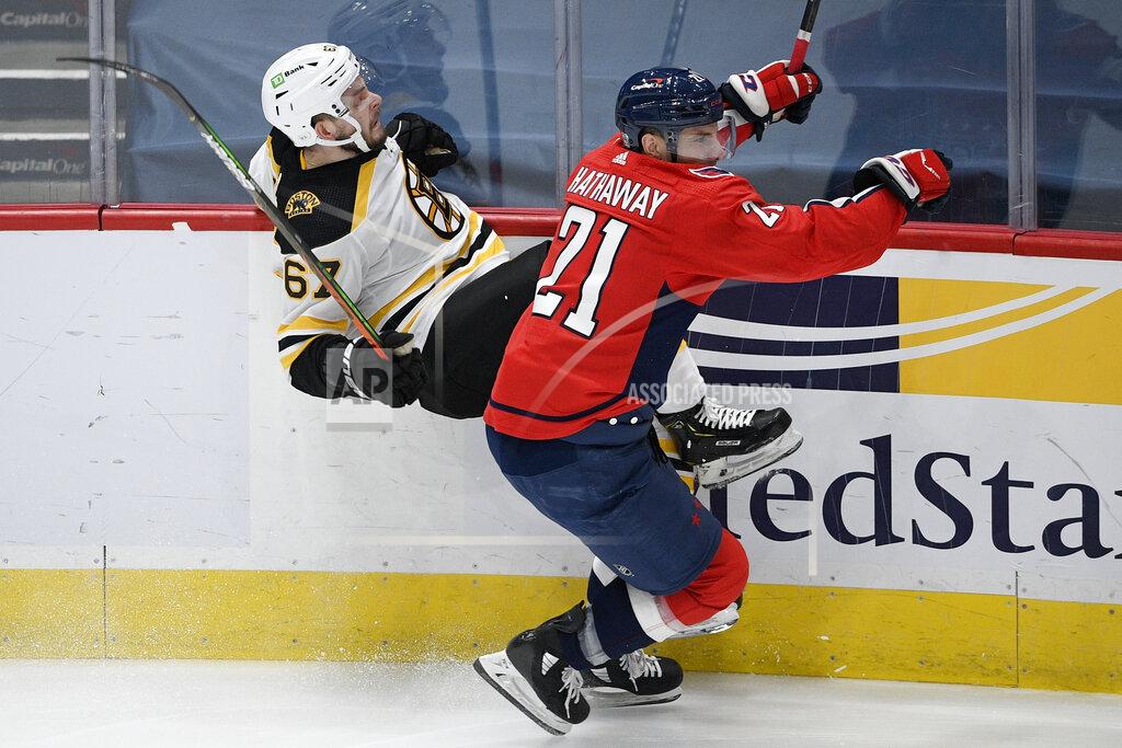Nick Wass Washington Capitals right wing Garnet Hathaway (21) checks Boston Bruins defenseman Jakub Zboril (67) during the first period of an NHL hockey game, Monday, Feb. 1, 2021, in Washington. (AP Photo/Nick Wass)