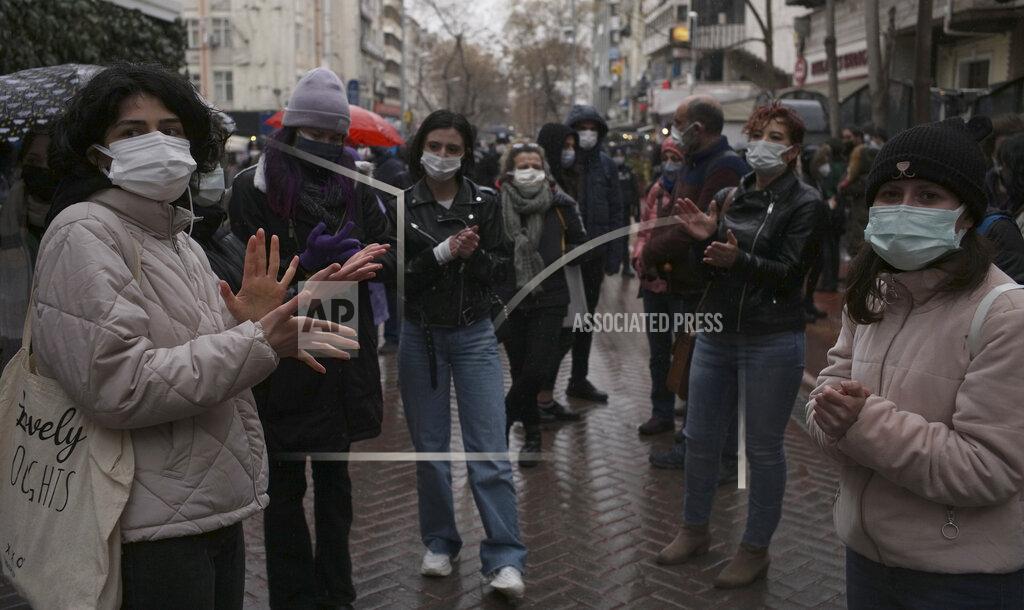 Burhan Ozbilici Women wearing masks to protect against the spread of coronavirus, stand in the rain during a women's right protest, in Ankara, Turkey, Saturday, March 20, 2021. Turkey's weekly geographic COVID-19 figures keep increasing according to Health ministry statistics released late Saturday as the country continues its "controlled normalization." (AP Photo/Burhan Ozbilici)