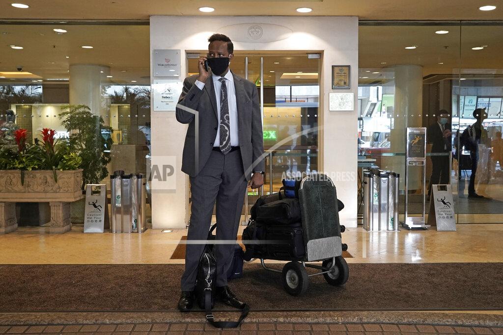 Kin Cheung A hotel guest wearing a face mask, waits for transportation after checking out of the Royal Garden Hotel in Hong Kong, Friday, Oct. 9, 2020. The Royal Garden Hotel was evacuating all of its guests after the government confirmed that a waiter who worked at a Vietnamese restaurant at the hotel was found to have the coronavirus COVID-19. (AP Photo/Kin Cheung)