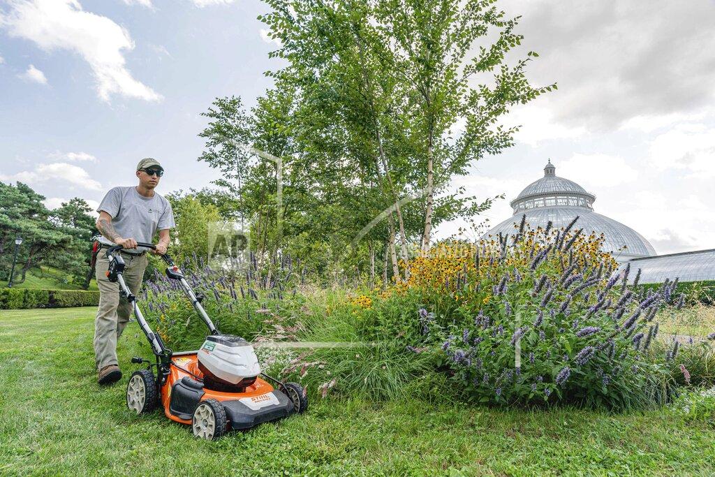 Marlon Co This undated image released by the New York Botanical Garden shows Tyler Campbell mowing the grounds in front of the Enid A. Haupt Conservatory at the New York Botanical Garden in the Bronx borough of New York. (Marlon Co/New York Botanical Garden via AP)