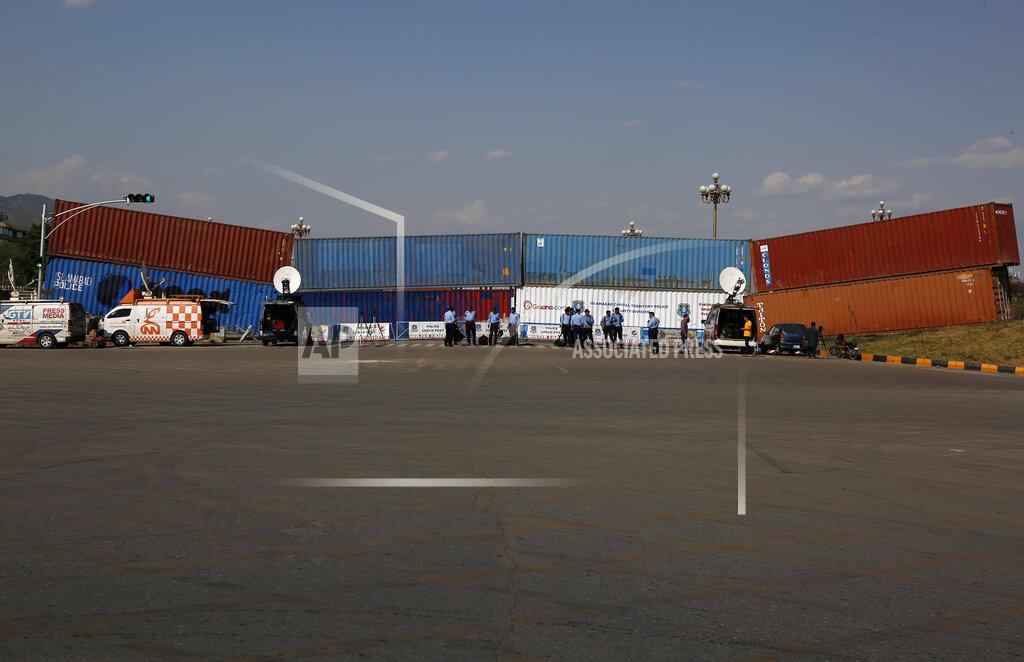 Anjum Naveed Police officers stand guard next to shipping containers placed by authorities to block a road leading to important government buildings in an attempt to foil a planned rally by Pakistan's key opposition party, in Islamabad, Pakistan, Tuesday, May 24, 2022. Pakistan banned ousted Prime Minister Imran Khan from holding a massive rally in the capital of Islamabad and cracked down on his supporters in overnight raids across the country, arresting hundreds. (AP Photo/Anjum Naveed)