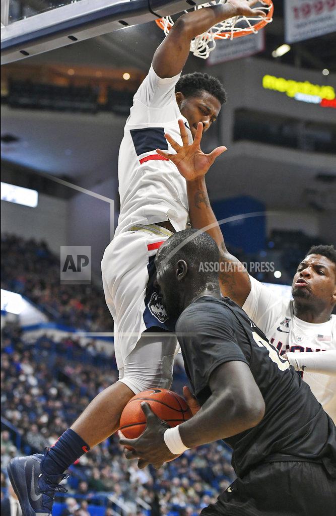 Jessica Hill Connecticut's Alterique Gilbert, top, and Eric Cobb, right, defend against Central Florida's Tacko Fall during the first half of an NCAA college basketball game, Saturday, Jan. 5, 2019, in Hartford, Conn. (AP Photo/Jessica Hill)