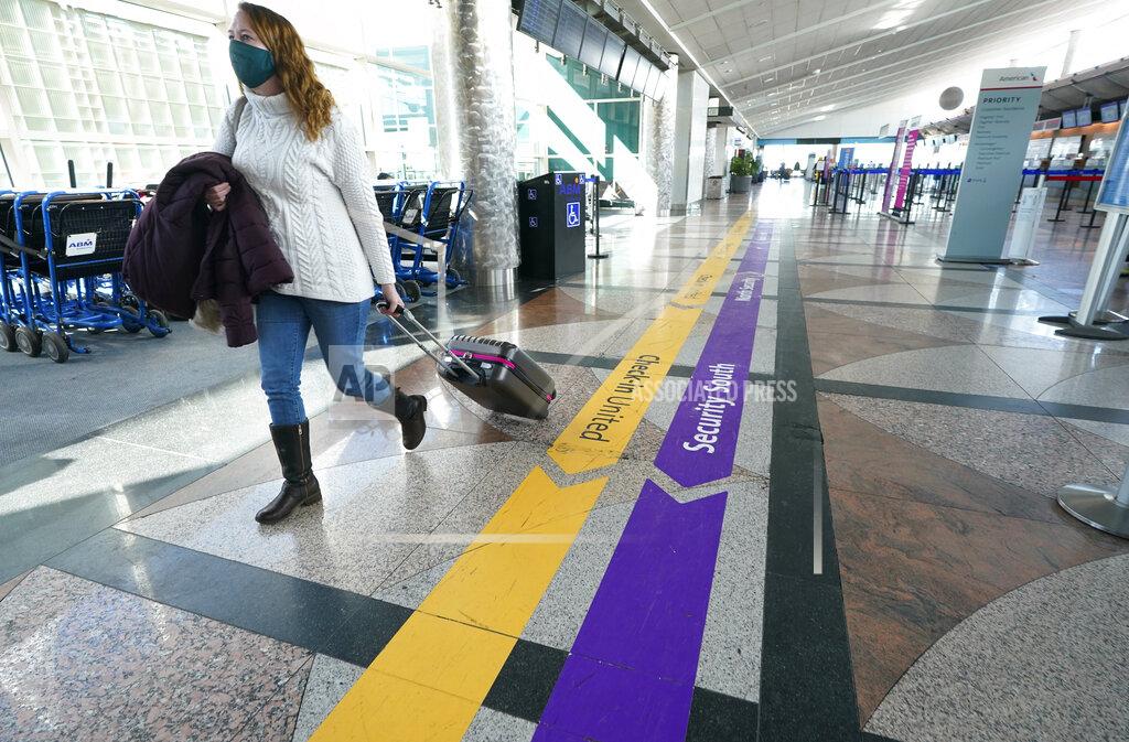 David Zalubowski FILE - In this Feb. 18, 2021, file photo, a lone traveler wears a face covering while hurrying through a near-empty check-in counter area in the main terminal of Denver International Airport, in Denver. After a year of ghostly airports, empty sports stadiums and constant Zoom meetings, growing evidence suggests that the economy is strengthening. Hiring picked up in February 2021. Business restrictions have eased as the pace of viral infections has ebbed. Yet the economy remains far from normal. (AP Photo/David Zalubowski, File)