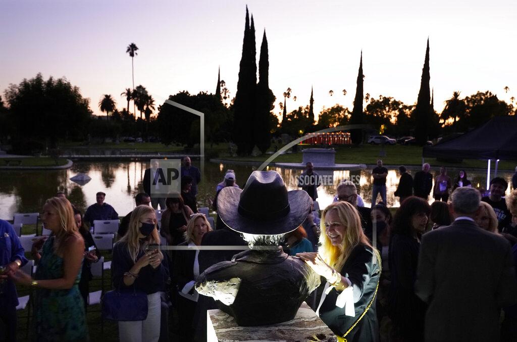 Chris Pizzello Guests gather around a newly unveiled memorial sculpture of the late actor Burt Reynolds following a ceremony at Hollywood Forever Cemetery, Monday, Sept. 20, 2021, in Los Angeles. Reynolds died in 2018 at the age of 82. (AP Photo/Chris Pizzello)