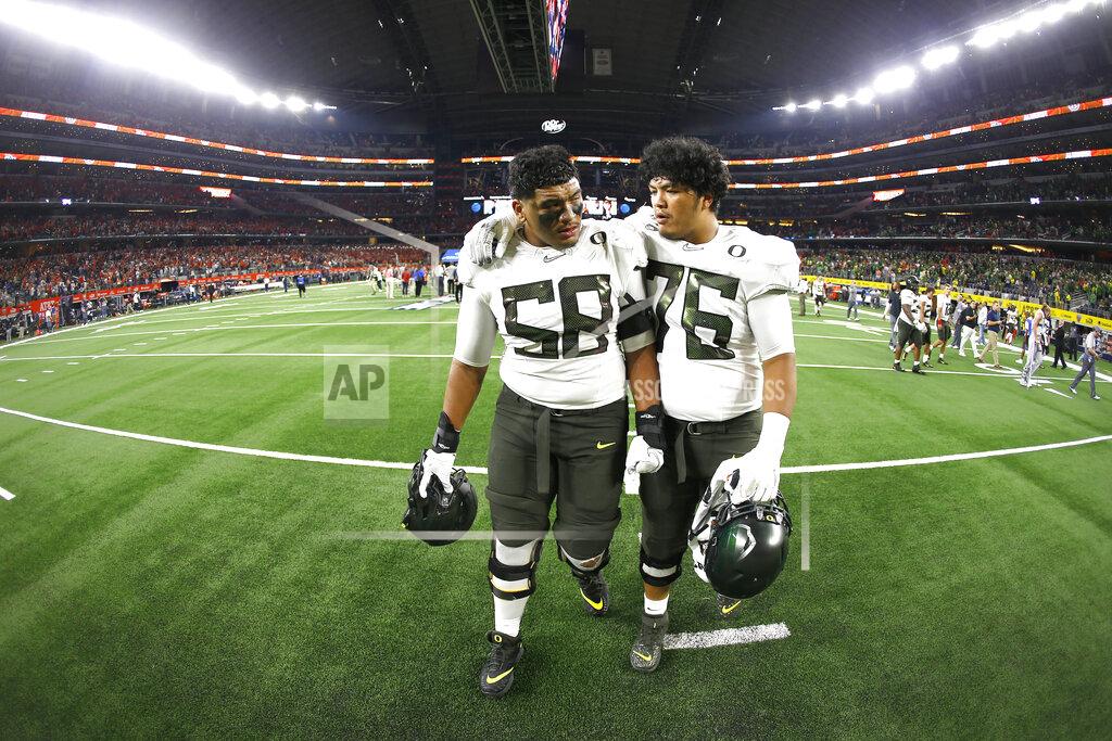 Ron Jenkins Oregon offensive linemen Penei Sewell (58) and Jonah Tauanu'u (76) walk off the field after the team's 27-21 loss to Auburn following an NCAA college football game, Saturday, Aug. 31, 2019, in Arlington, Texas. (AP Photo/Ron Jenkins)