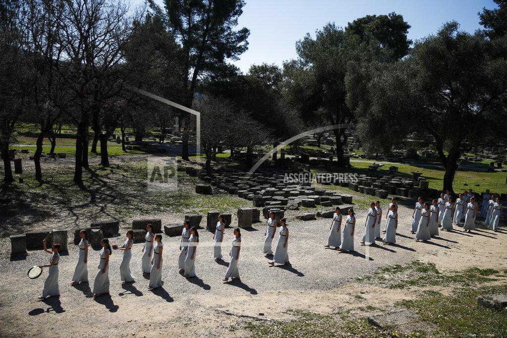 Thanassis Stavrakis Actresses, playing the role of priestesses, performance during the flame lighting ceremony at the closed Ancient Olympia site, birthplace of the ancient Olympics in southern Greece, Thursday, March 12, 2020, 2020. Greek Olympic officials are holding a pared-down flame-lighting ceremony for the Tokyo Games due to concerns over the spread of the coronavirus. Both Wednesday's dress rehearsal and Thursday's lighting ceremony are closed to the public, while organizers have slashed the number of officials from the International Olympic Committee and the Tokyo Organizing Committee, as well as journalists at the flame-lighting. (AP Photo/Thanassis Stavrakis)