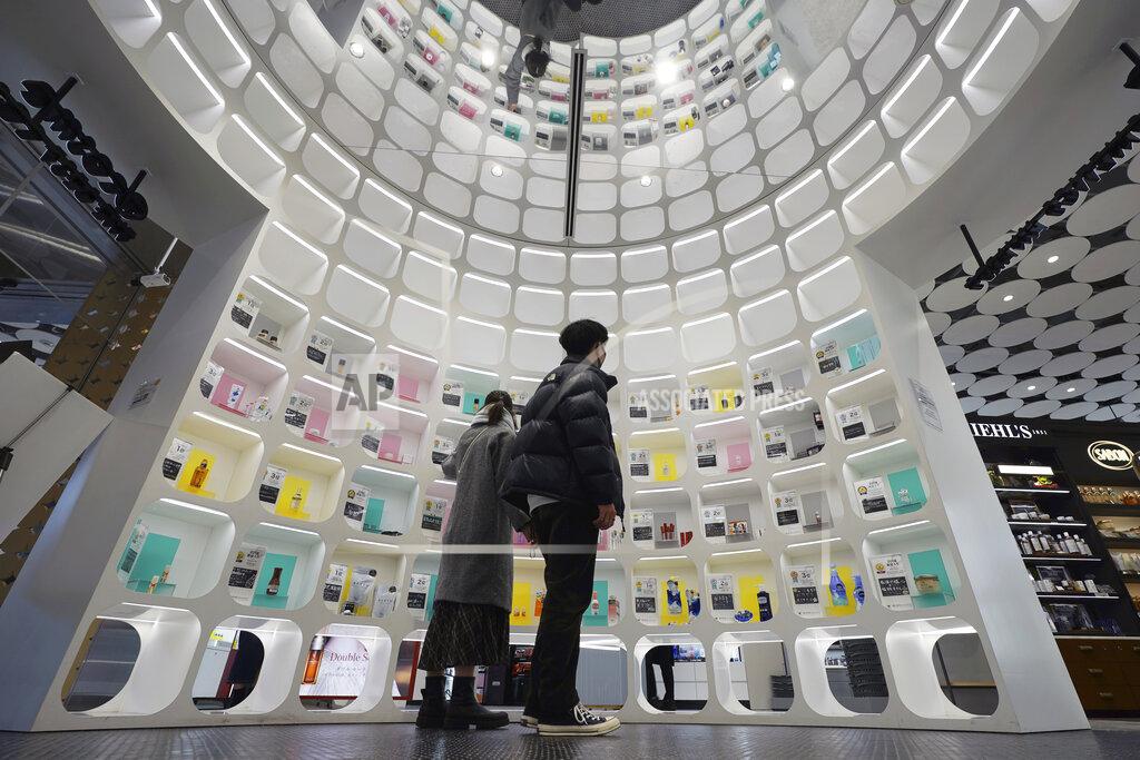 Eugene Hoshiko Visitors look at beauty products at @cosme TOKYO, a store selling a selection of cosmetics and makeup products including men's cosmetic, in Tokyo's Harajuku district Tuesday, Feb. 9, 2021. The coronavirus pandemic has been pushing businesses to the edge in Japan, but some in the men's beauty industry have seen an unexpected expansion in their customer base. Japanese businessmen in their 40s, 50s and 60s who had little interest in cosmetics before the pandemic are now buying makeup. (AP Photo/Eugene Hoshiko)