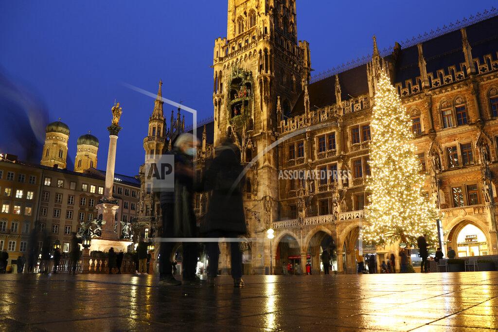 Matthias Schrader People wearing face masks in front of a giant Christmas tree at the famous 'Marienplatz' in Munich, Germany, Sunday, Dec. 6, 2020. Christmas markets are canceled or diminished because of the coronavirus pandemic this year. (AP Photo/Matthias Schrader)