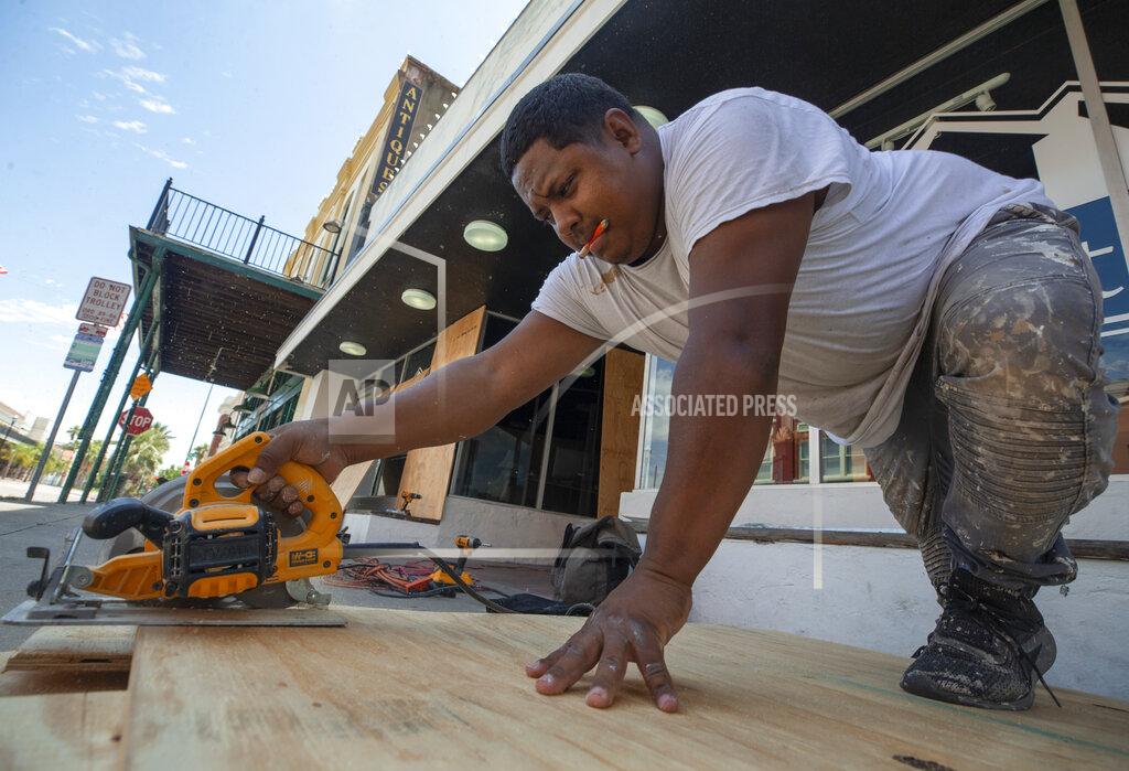 Stuart Villanueva Osman Antunez cuts plywood to cover the windows at Stonewater, Inc. Disaster Relief on Post Office Street in downtown Galveston Tuesday, Aug 25, 2020. Local businesses continued to make preparations for Hurricane Laura's arrival along the gulf coast. (Stuart Villanueva/The Galveston County Daily News via AP)
