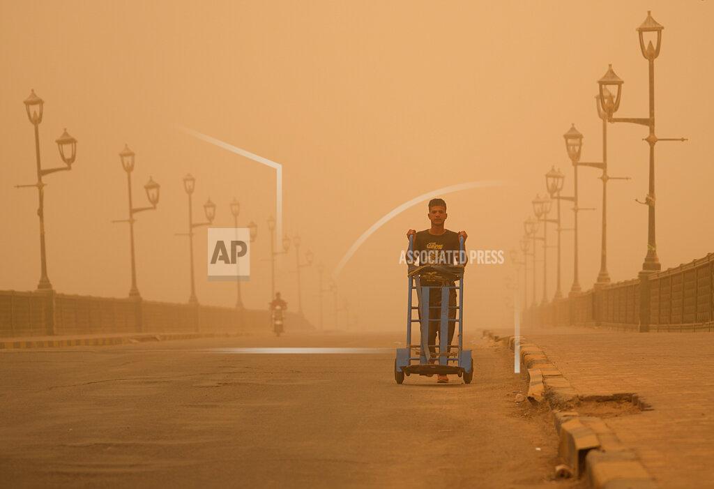Hadi Mizban A man pushes a cart during a sandstorm in Baghdad, Iraq, Monday, May 23, 2022. (AP Photo/Hadi Mizban)