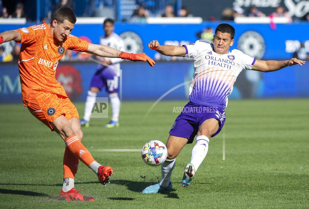 Graham Hughes CF Montreal goalkeeper Sebastian Breza, left, clears the ball as Orlando City's Cesar Araujo moves in during the second half of an MLS soccer game in Montreal, Saturday, May 7, 2022. (Graham Hughes/The Canadian Press via AP)