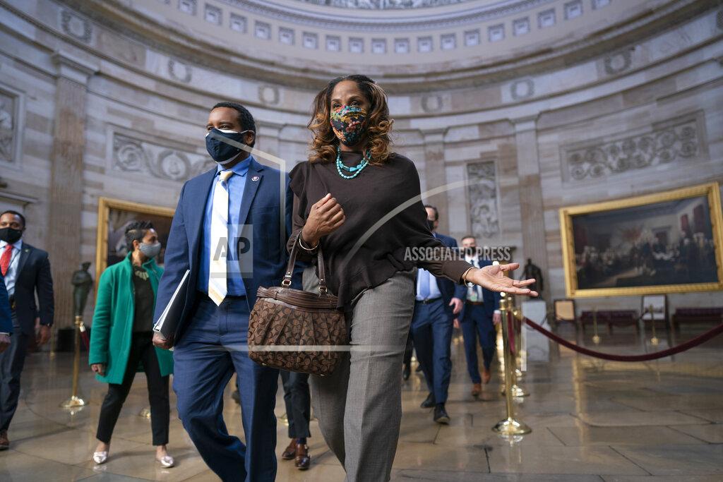 J. Scott Applewhite On the eve of the second impeachment trial of former President Donald Trump, Rep. Joe Neguse, D-Colo., left, Del. Stacey Plaskett, D-Virgin Islands, right, and the other Democratic House impeachment managers walk through the Rotunda to the Senate to prepare for the case, at the Capitol in Washington, Monday, Feb. 8, 2021. The trial will begin Tuesday with a debate and vote on whether it's even constitutional to prosecute the former president, an argument that could resonate with Republicans keen on voting to acquit Trump. (AP Photo/J. Scott Applewhite)