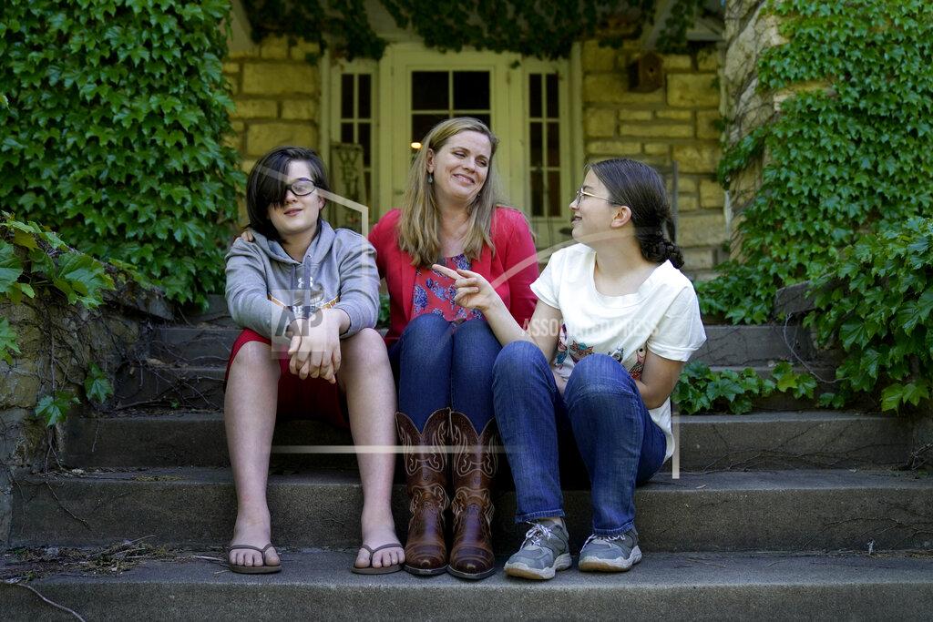 Charlie Riedel Heather Ousley sits with her older children Elliannah, 15, right, and Samuel, 13, in front of their home in Merriam, Kan, Tuesday, May 4, 2021. Ousley was thrilled when she heard the FDA was expected to authorize Pfizer's COVID-19 vaccine for youngsters ages 12 to 15 and was hoping to get her kids vaccinated as soon as she can. (AP Photo/Charlie Riedel)