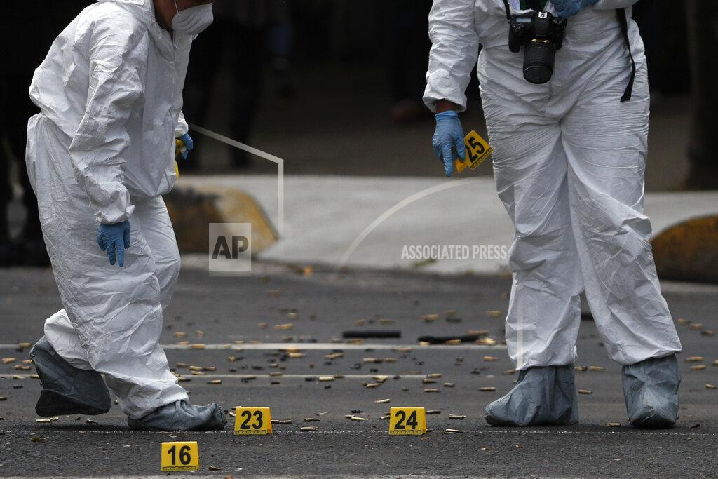 Rebecca Blackwell Forensic investigators tag cartridges at the scene where the Mexican capital's police chief was attacked by gunmen in Mexico City, Friday, June 26, 2020. Heavily armed gunmen attacked and wounded Omar Garcia Harfuch in an operation that left several dead. (AP Photo/Rebecca Blackwell)