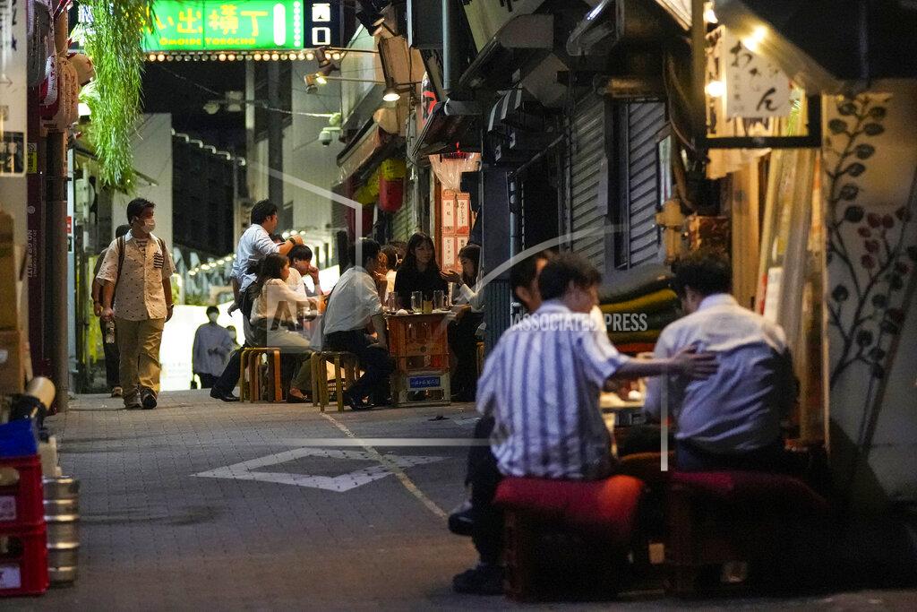 Kiichiro Sato FILE - In this Sept. 22, 2021, file photo, people gather at bars that are open and serving alcohol on an ally filled with bars and restaurants despite Tokyo government has requested businesses not to serve alcohol under a state of emergency, in Tokyo. People in Tokyo could eat and drink inside bars and restaurants for longer evening hours starting Monday, Oct. 25, 2021 as officials eased social distancing rules with the country’s daily coronavirus cases reaching its lowest levels in more than a year. (AP Photo/Kiichiro Sato, File)