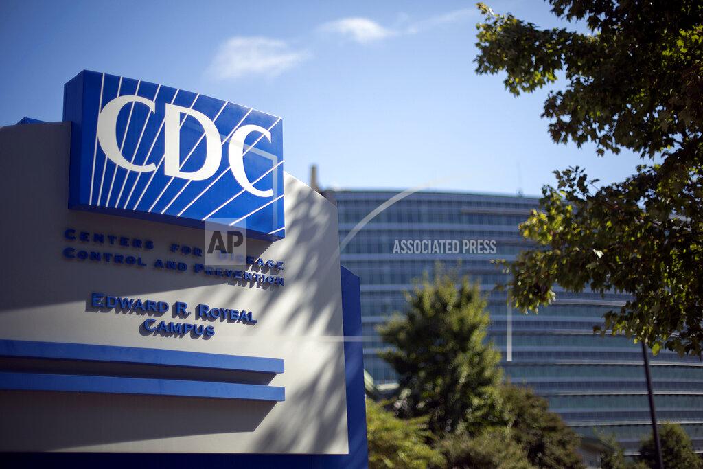 FILE - In this Oct. 8, 2013, file photo, a sign marks the entrance to the federal Centers for Disease Control and Prevention in Atlanta. In the United States, the nation with the most pandemic deaths, the reporting of vital coronavirus case and testing data is not keeping pace with its speedy spread. Public health officials nationwide lean too heavily on faxes, email and spreadsheets, sluggish and inefficient 20th-century tools. (AP Photo/David Goldman, File)