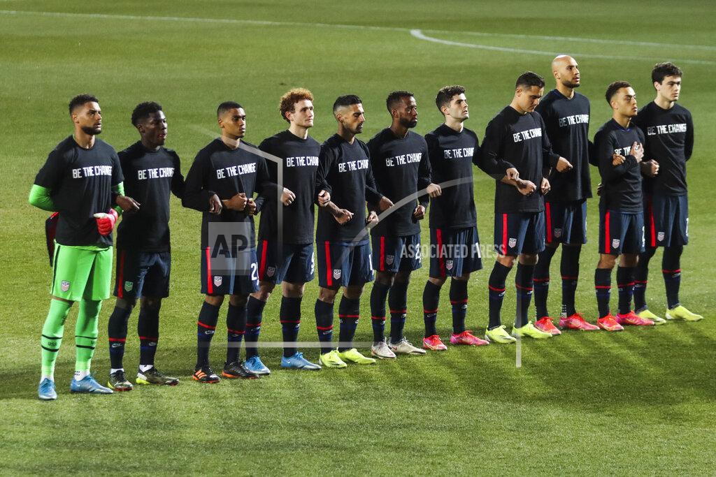 Ronald Zak US players stand during the national anthem prior the international friendly soccer match between USA and Jamaica at SC Wiener Neustadt stadium in Wiener Neustadt, Austria, Thursday, March 25, 2021. (AP Photo/Ronald Zak)