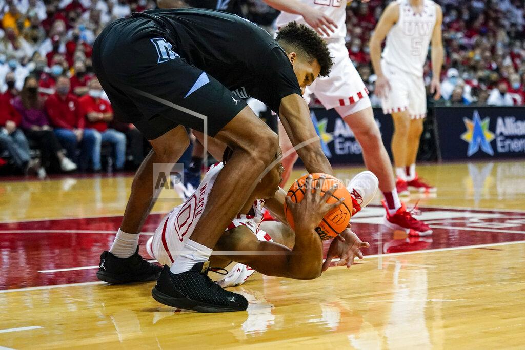 Andy Manis Marquette's Oso Ighodaro, top, and Wisconsin's Jahcobi Neath (0) battle for a loose ball during the first half of an NCAA college basketball game Saturday, Dec. 4, 2021, in Madison, Wis. (AP Photo/Andy Manis)