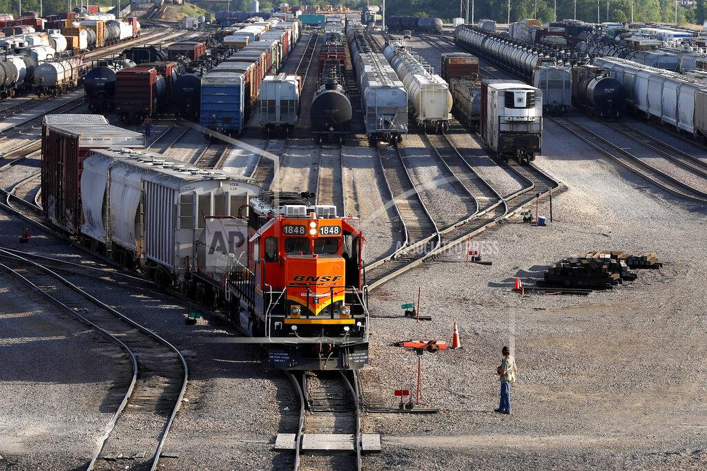 Shafkat Anowar FILE- A BNSF rail terminal worker monitors the departure of a freight train, on June 15, 2021, in Galesburg, Ill. BNSF railroad is tweaking its strict new attendance policy, but the unions that have challenged the rules that took effect in February say the changes don't go far enough. The railroad told employees that starting next month it will make several small changes in the formula it uses to determine whether workers are missing too many shifts, but unions say the rules still do too much to encourage workers to show up when they are sick or fatigued and they have contributed to more than 700 employees leaving the railroad at a time when BNSF is struggling to hire. (AP Photo/Shafkat Anowar, File)