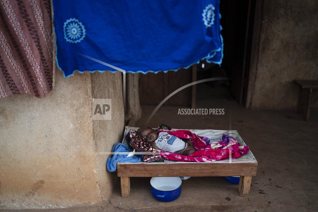 Leo Correa A baby sleeps at the entrance of his house in Komao village, on the outskirts of Koidu, district of Kono, Sierra Leone, Sunday, Nov. 22, 2020. (AP Photo/Leo Correa)
