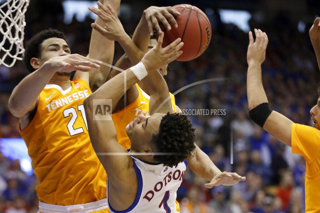 Orlin Wagner Tennessee guard Jalen Johnson, back, and forward Olivier Nkamhoua (21) block a shot by Kansas guard Devon Dotson (1) during the first half of an NCAA college basketball game in Lawrence, Kan., Saturday, Jan. 25, 2020. (AP Photo/Orlin Wagner)