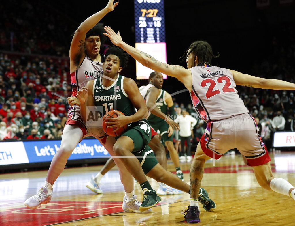 Noah K. Murray Michigan State guard A.J. Hoggard (11) drives to the basket against Rutgers forward Ron Harper Jr. (24) and guard Caleb McConnell (22) during the first half of an NCAA college basketball game in Piscataway, N.J., Saturday, Feb. 5, 2022. (AP Photo/Noah K. Murray)