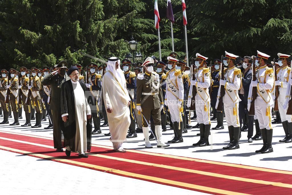 Uncredited In this photo released by the official website of the office of the Iranian Presidency, Qatari Emir Sheikh Tamim bin Hamad Al Thani, second left, reviews an honor guard as he is welcomed by President Ebrahim Raisi, left, during an official arrival ceremony at the Saadabad Palace in Tehran, Iran, Thursday, May 12, 2022. Qatar's emir arrived in Tehran for talks with the Iranian president as efforts to save Tehran's tattered nuclear deal with world powers hit a deadlock. (Iranian Presidency Office via AP)