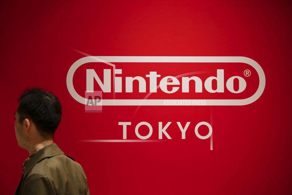 FILE - In this Jan. 23, 2020, file photo, a shopper stands in front of a Nintendo sign at Nintendo's official store the Shibuya shopping district in Tokyo. Nintendo Co. reported Monday, Feb. 1, 2021 that its profit for the first three fiscal quarters nearly doubled as people around the world stayed home for the pandemic and turned to playing games. (AP Photo/Jae C. Hong, File)