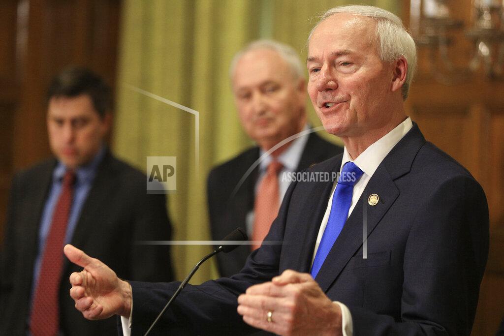 Staton Breidenthal FILE - In this March 23, 2020 file photo, Gov. Asa Hutchinson, right, speaks in Little Rock Ark. Gov. Hutchinson is resisting issuing a broad stay-at-home order to curb the coronavirus outbreak, even as the state's cases continue to increase. Health officials on Thursday, March 2, 2020, said the number of coronavirus cases in the state had risen to at least 643, with two additional deaths. (Staton Breidenthal/The Arkansas Democrat-Gazette via AP File)