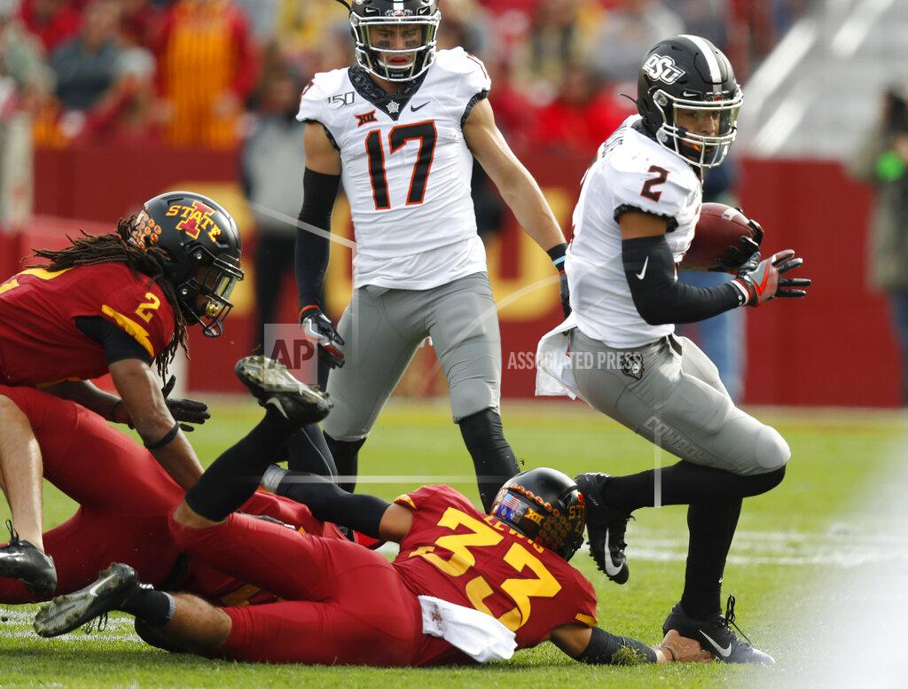 Matthew Putney Oklahoma State wide receiver Tylan Wallace, right, breaks free from Iowa State defensive back Braxton Lewis, center, to score a touchdown during the first half of an NCAA college football game, Saturday, Oct. 26, 2019, in Ames, Iowa. (AP Photo/Matthew Putney)