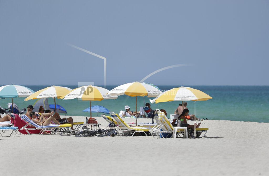 Wilfredo Lee Beach goers enjoy a day at the beach, Tuesday, June 30, 2020, on Miami Beach, Florida's famed South Beach. Beaches in Miami-Dade County will be closed from Friday, July 3 through Monday, July 6. (AP Photo/Wilfredo Lee)