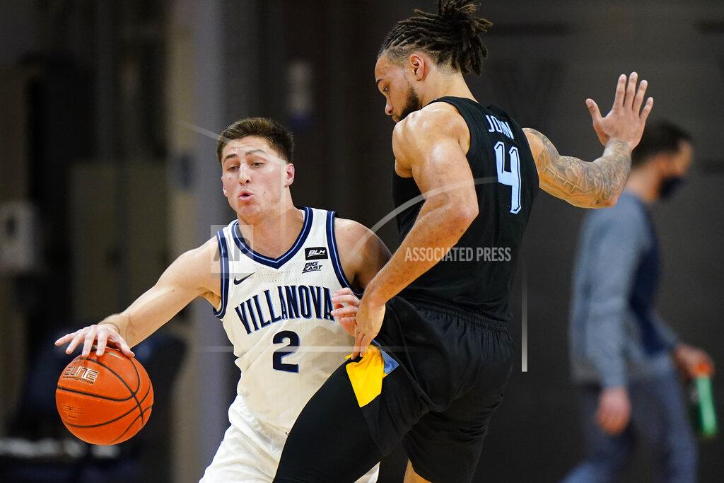 Matt Slocum Villanova's Collin Gillespie, left, tries to get past Marquette's Theo John during the second half of an NCAA college basketball game, Wednesday, Feb. 10, 2021, in Villanova, Pa. (AP Photo/Matt Slocum)
