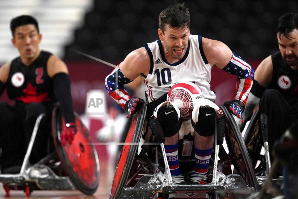Shuji Kajiyama Joshua Wheeler of the United States carries a ball against Canada's defense during a Pool Phase Group match of Wheelchair Rugby at the Tokyo 2020 Paralympic Games, Thursday, Aug. 26, 2021, in Tokyo, Japan. (AP Photo/Shuji Kajiyama)