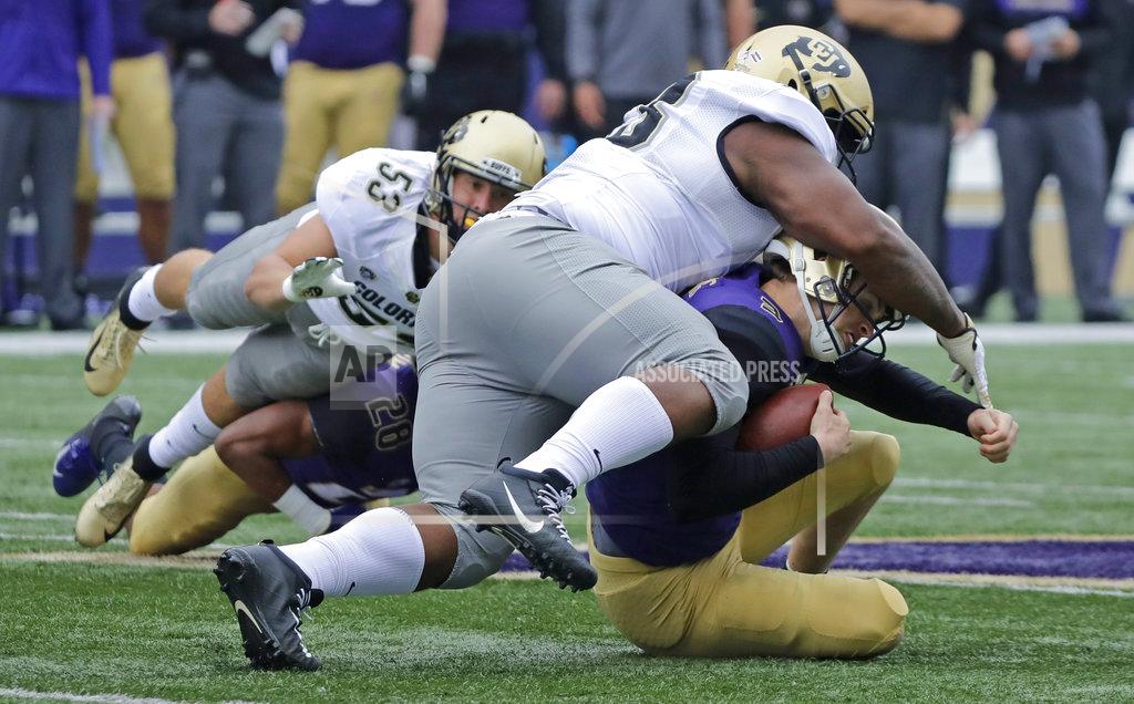 Ted S. Warren Washington quarterback Jake Browning, lower right, is tackled by Colorado's Javier Edwards, upper right, during the first half of an NCAA college football game, Saturday, Oct. 20, 2018, in Seattle. (AP Photo/Ted S. Warren)