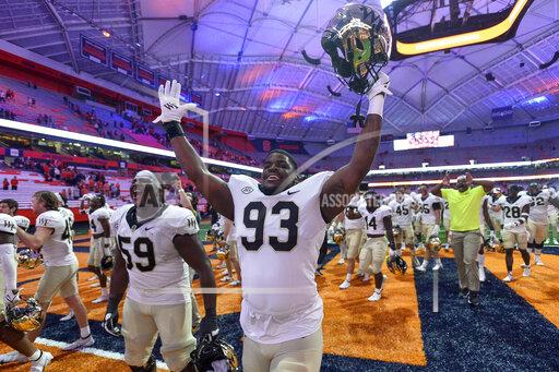 Wake Forest offensive lineman Loic Ngassam Nya (59) and defensive lineman Isaiah Chaney (93) celebrate after a 40-37 overtime win against Syracuse in an NCAA college football game in Syracuse, N.Y., Saturday, Oct. 9, 2021. (AP Photo/Adrian Kraus)