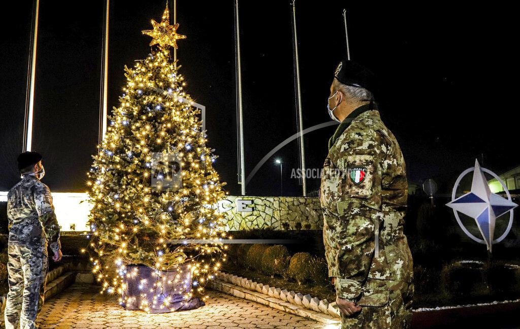 Uncredited In this photo provided by NATO-led peacekeeping mission in Kosovo (KFOR), Italian soldiers watch Christmas tree on the Christmas Eve in the KFOR military headquarters in Kosovo capital Pristina, Thursday, Dec. 24, 2020. The coronavirus pandemic has totally changed Christmas time operation method and celebrations for the Kosovo Force but it has left unchanged its mission: keeping Kosovo safe and secure for 22 years now on. (KFOR via AP)