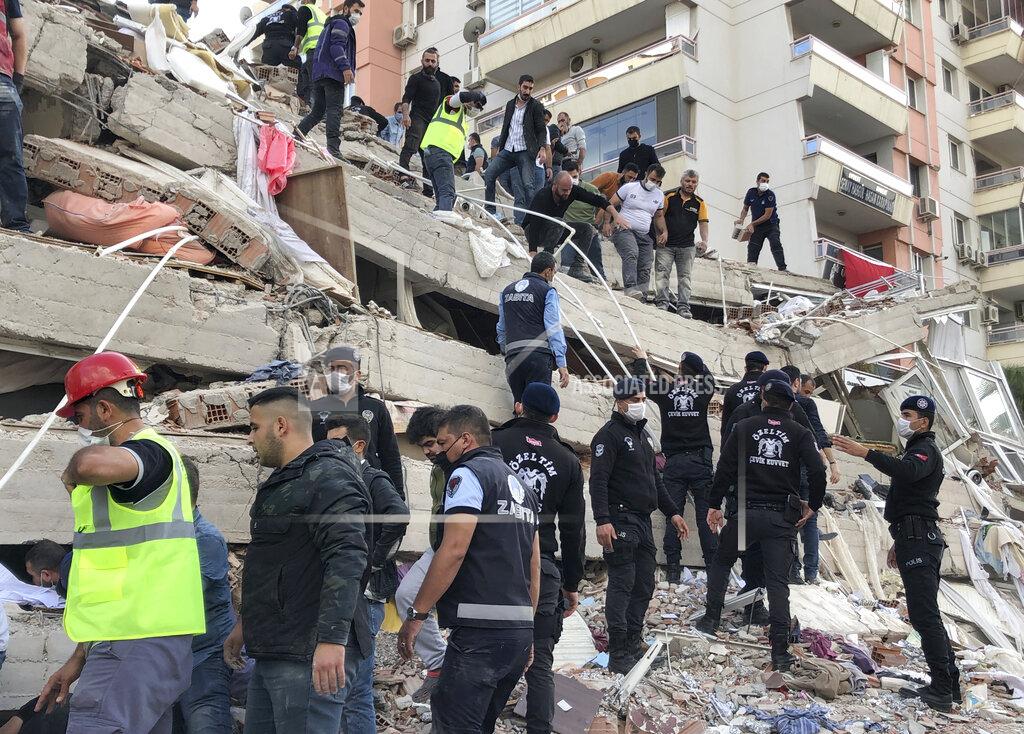 Ismail Gokmen Rescue workers and local people try to save residents trapped in the debris of a collapsed building, in Izmir, Turkey, Friday, Oct. 30, 2020, after a strong earthquake in the Aegean Sea has shaken Turkey and Greece. Turkey's Disaster and Emergency Management Presidency said Friday's earthquake was centered in the Aegean at a depth of 16,5 kilometers (10.3 miles) and registered at a 6.6 magnitude.(AP Photo/Ismail Gokmen)