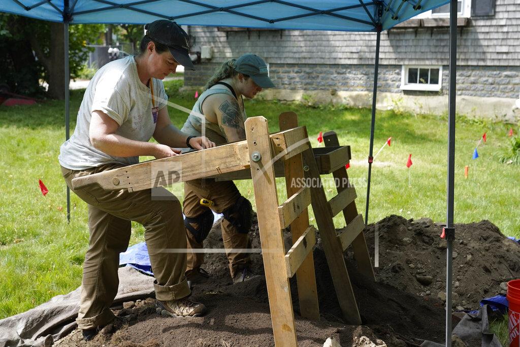 Steven Senne University of Massachusetts Boston research scientist Christa Beranek, of Arlington, Mass., left, and UMass graduate student Emily Willis, of Boston, right, sift soil through screens while searching for artifacts at an excavation site, Wednesday, June 9, 2021, on Cole's Hill, in Plymouth, Mass. The archaeologists are part of a team excavating the grassy hilltop that overlooks iconic Plymouth Rock one last time before a historical park is built on the site. (AP Photo/Steven Senne)