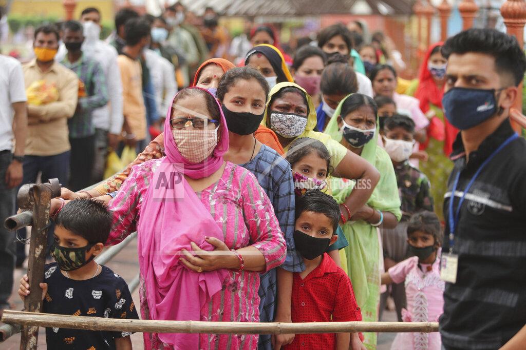 Channi Anand Hindu devotees wearing face masks as a precautionary measure against the coronavirus stand in a queue to offer prayers inside a temple dedicated to goddess Kali in Jammu, India, Tuesday, April 13, 2021. New infections have surged in the past month and India has now reported over 13.6 million cases — pushing its toll past Brazil, and making it second only to the United States. In the past 24 hours, over 160,000 new infections have been detected and experts fear that the worst is yet to come. (AP Photo/Channi Anand)
