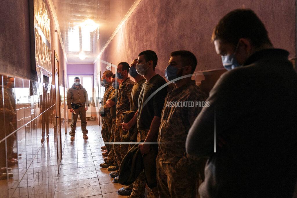 Evgeniy Maloletka Ukrainian servicemen stand in line as they wait to receive a dose of the AstraZeneca COVID-19 vaccine marketed under the name CoviShield at a military base in Kramatorsk, Ukraine, Tuesday, March 2, 2021. Ukraine plans to vaccinate 14.4 million people this year, or about 35% of its 41 million people. (AP Photo/Evgeniy Maloletka)