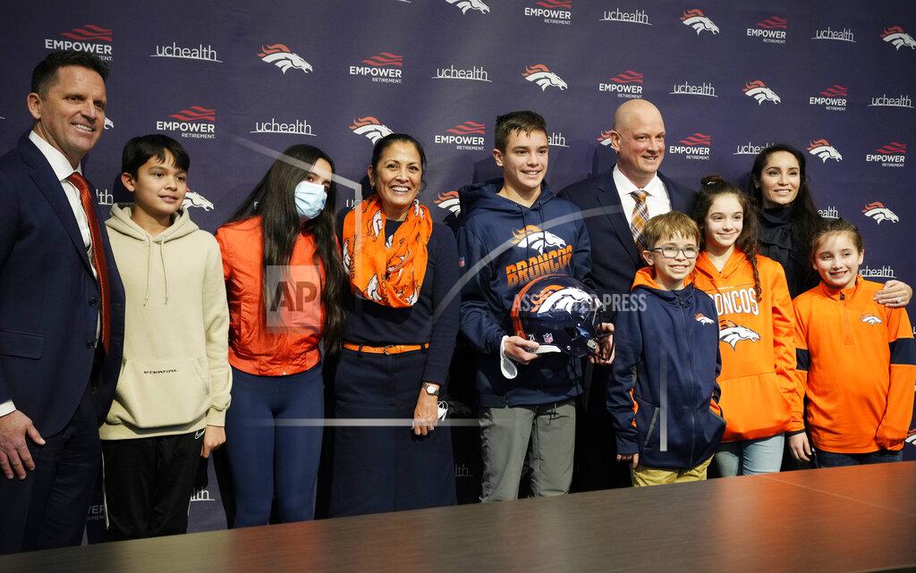 David Zalubowski From left, Denver Broncos general manager George Paton, his son Beau, 13, daughter Bella, 15, and wife Barb join the family of new Broncos head coach Nathaniel Hackett, six from left, and his children Harrison, 13, London, 11, Briar, 12, Everly, 9, and wife Megan for a photograph after a news conference Friday, Jan. 28, 2022, at the NFL football team's headquarters in Englewood, Colo. (AP Photo/David Zalubowski)