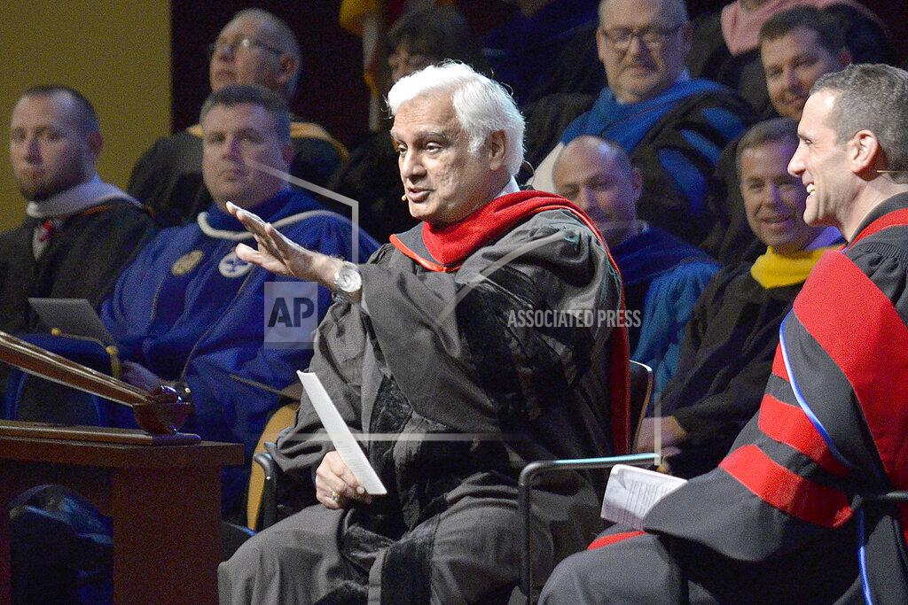 Jeff Morehead FILE - In this March 30, 2016 file photo, Ravi Zacharias, center, speaks during the Society of World Changers induction ceremony at Indiana Wesleyan University in Marion, Ind. Zacharias, who built an international ministry that strives to defend Christianity on intellectual grounds, died Tuesday, May 19, 2020 at his home in Atlanta after a brief battle with sarcoma, Ravi Zacharias International Ministries said in a statement. (Jeff Morehead/The Chronicle-Tribune via AP)